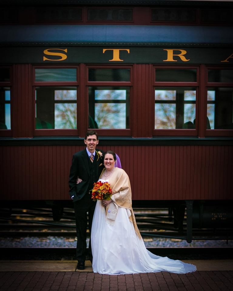 Bride and groom in front of train