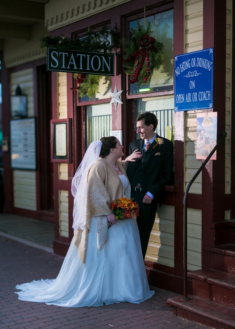 Bride and groom at ticket booth for train station