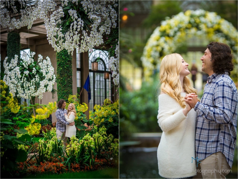 Engagement photo of couple embracing at longwood gardens in front of Orchids.
