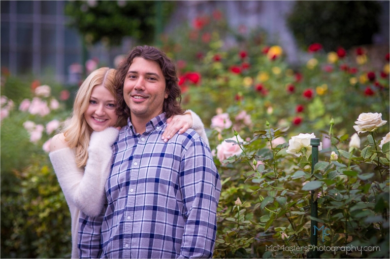 Engagement photo of couple in front of roses at longwood gardens