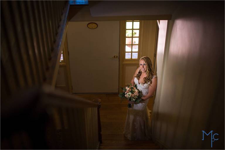Joseph Ambler Inn Wedding bride portrait at bottom of stairs with off camera lighting.
