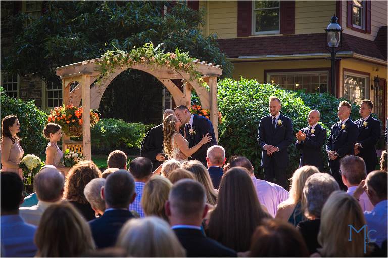 Joseph Ambler Inn wedding ceremony outdoor bride and groom kiss