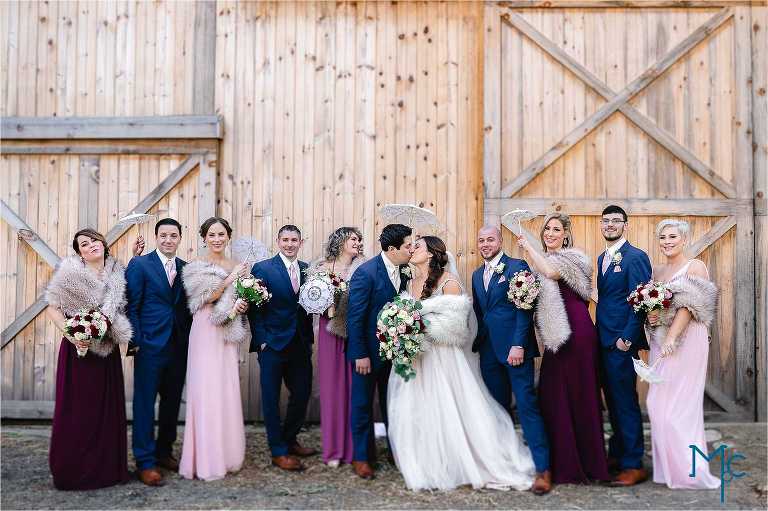Wedding party photo in front of rustic barn at Indian Orchards